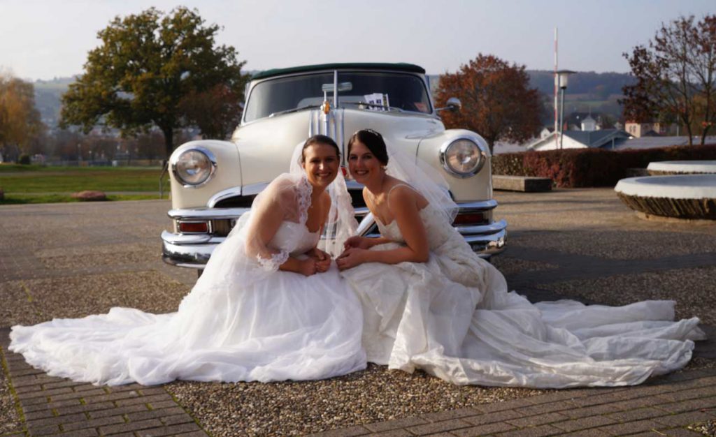 In Erbach 2 Brautmodels kniend vor Oldtimer